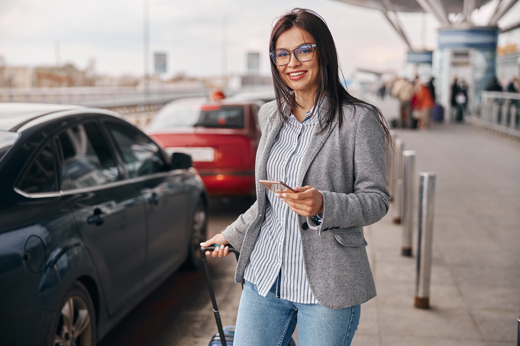Happy caucasian woman traveller in airport terminal is taking a taxi